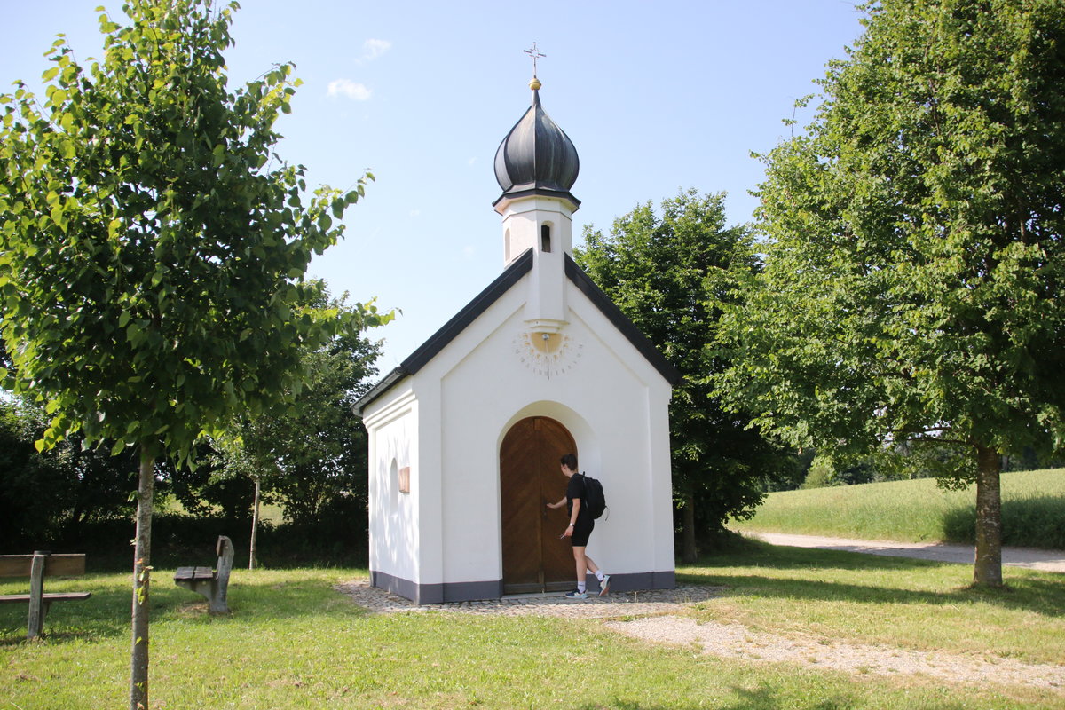 Ein Wanderer an der Tür einer Kapelle