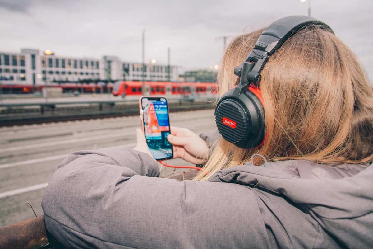 Eine Person mit Kopfhörern hört Musik über ihr Smartphone