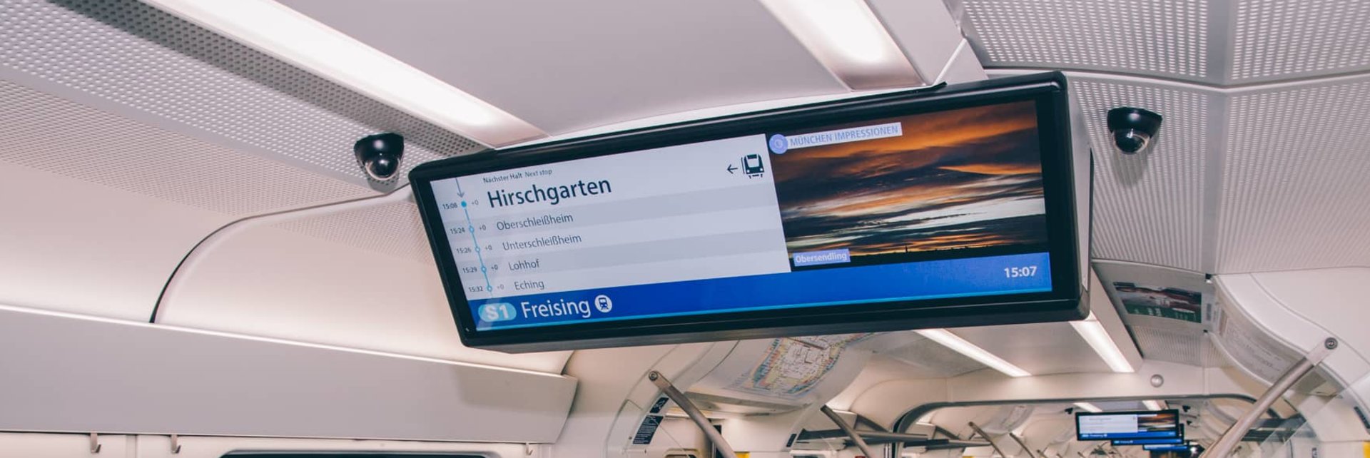 Innenansicht einer S-Bahn mit Deckenbildschirmen
