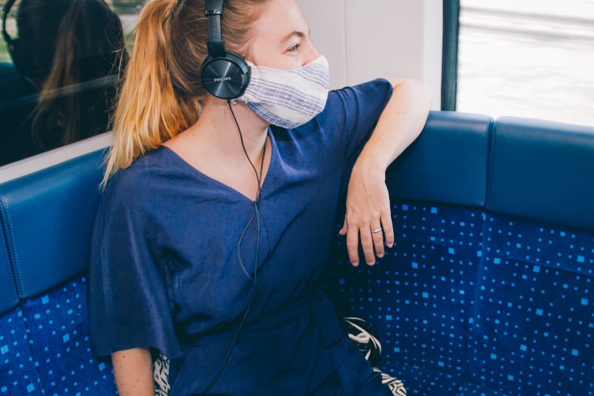 Frau in der S-Bahn hört über Kopfhörer Musik
