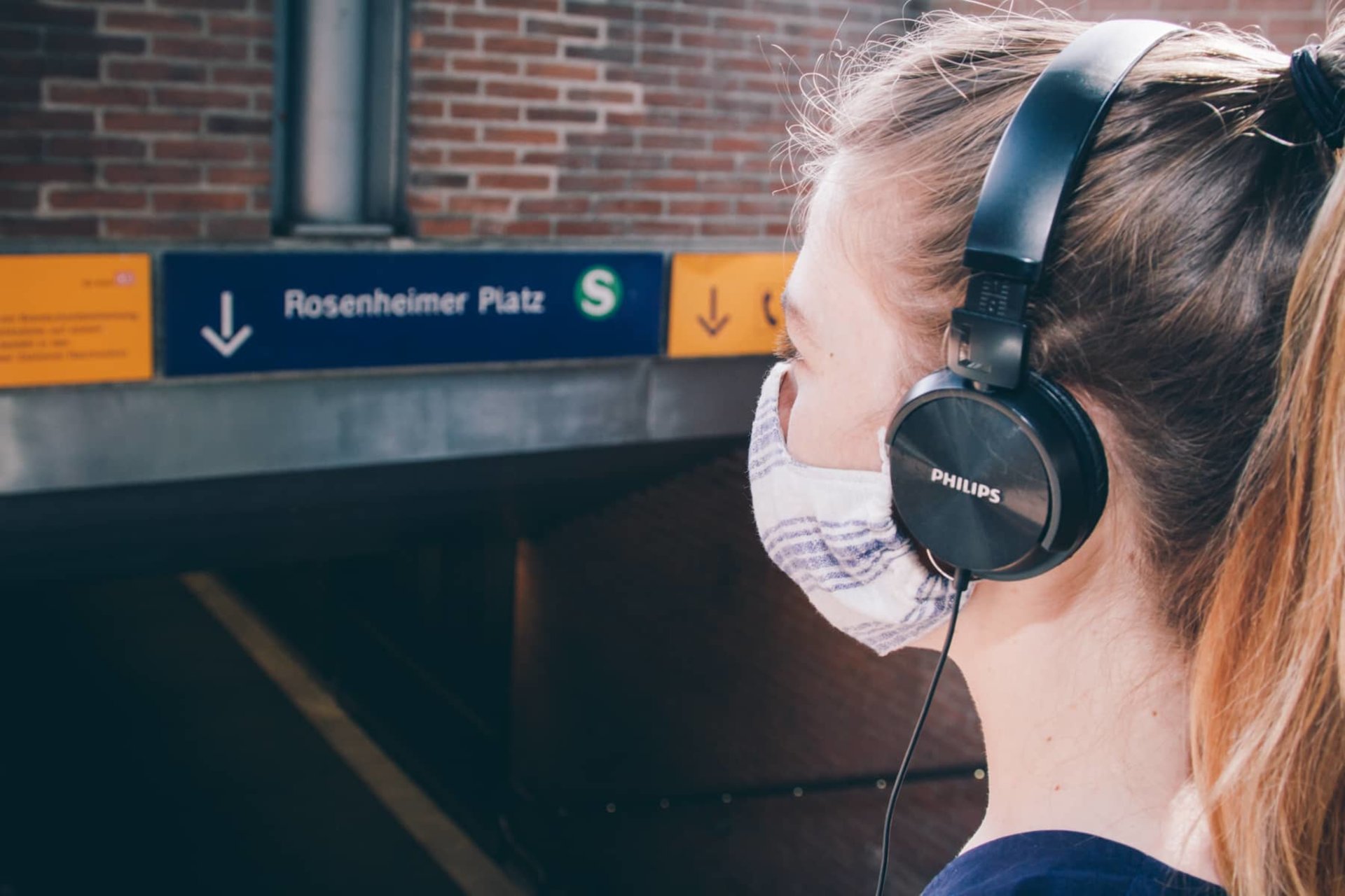 Frau mit Kopfhörern am Eingang zur S-Bahn Station Rosenheimer Platz