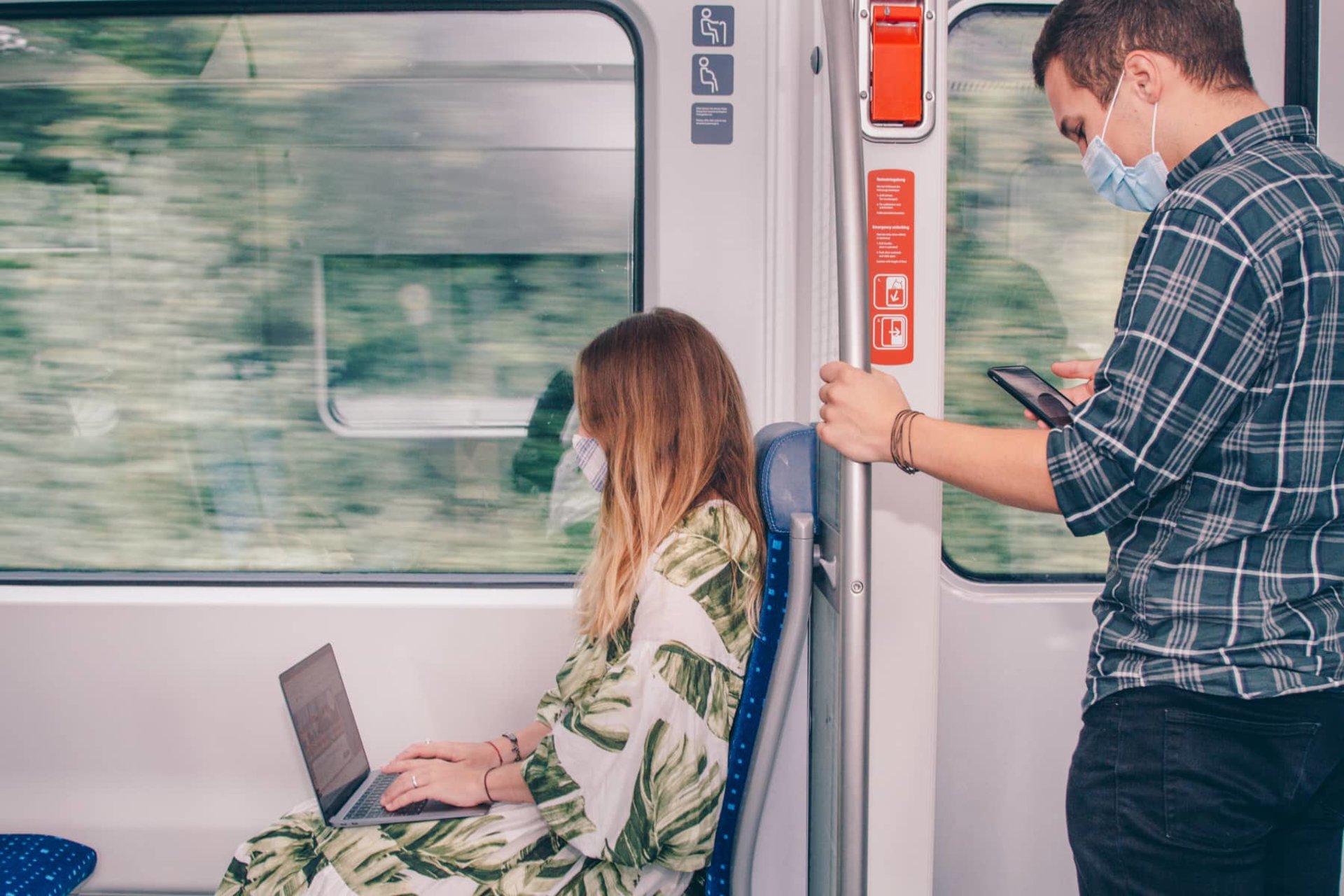 Personen nutzen Laptop und Smartphone in der S-Bahn